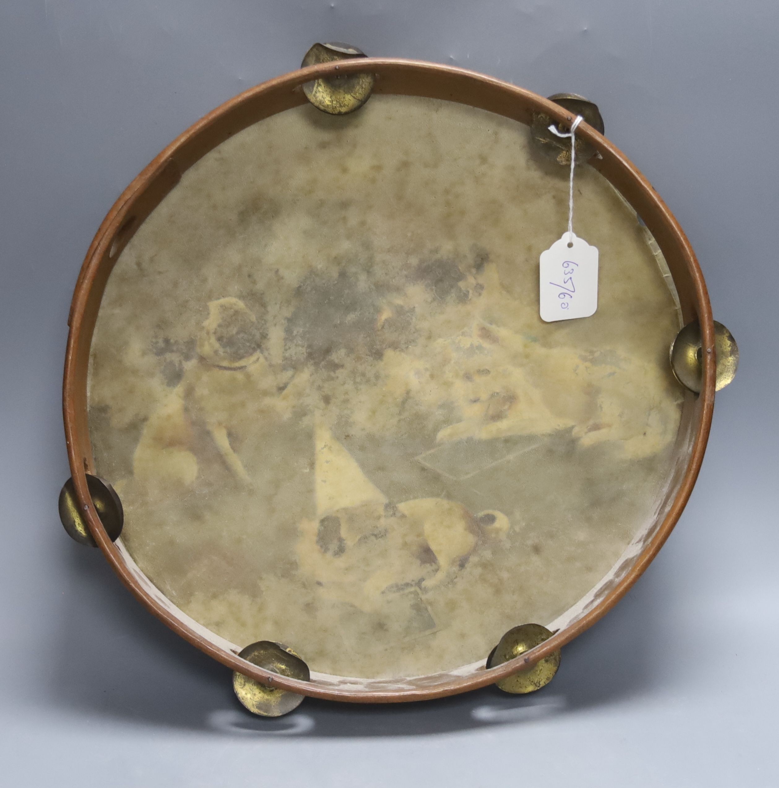 A painted tambourine, inscribed 'Fractions!’, the vellum decorated in oils with a group of small dogs learning mathematics, Dia 38cm